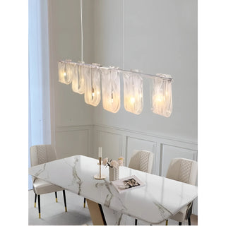 Liora linear pendant light above dining table side view with soft ambient lighting