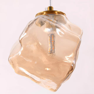 Close-up of a hand-formed amber rock glass pendant shade with brass fitting on the Lithara chandelier