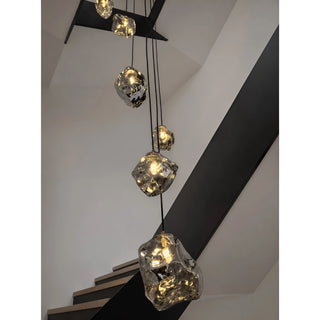 Detail of a rock glass pendant with warm integrated LED light on the Lithara staircase chandelier
