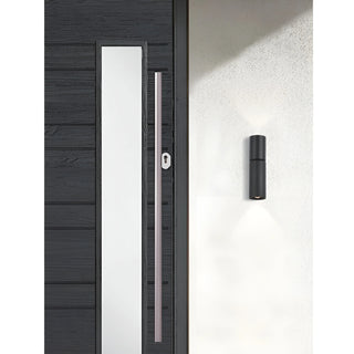 Black LED wall light mounted by front entrance, casting vertical light beams in both directions