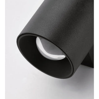 Detailed view of the integrated optical lens in cylindrical black LED sconce