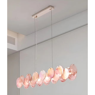Blush Pink Lumière Éclat rectangular glass chandelier installed over modern dining table with warm ambient lighting