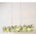 Lumière Éclat rectangular glass disc chandelier in Emerald Green finish suspended over dining table with sculptural layered glass discs