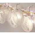 Detailed view of brass frame and textured white glass discs of Lumière Éclat rectangular chandelier