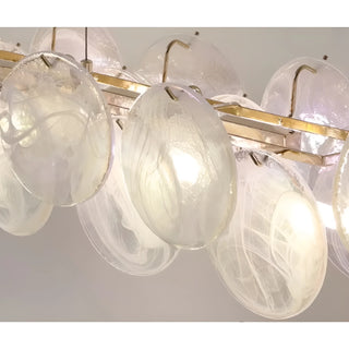 Detailed view of brass frame and textured white glass discs of Lumière Éclat rectangular chandelier