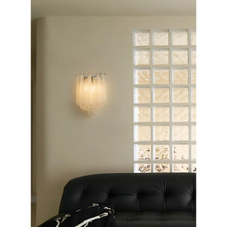 Modern textured glass wall sconce illuminating a contemporary living space with glass block windows and black leather seating