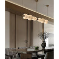 Modern marble linear chandelier above dining table with architectural lighting