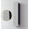 Wall sconce with inset view of marble-effect material, highlighting rich veining pattern