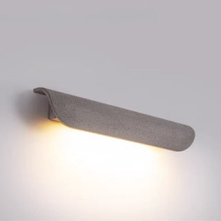 Wide-angle view of gray wall light showcasing its soft glow and modern curve design
