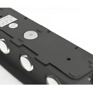 Close-up top view of minimalist LED wall light in matte black finish showing six-beam lens detail and mounting points