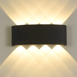 Illuminated front view of minimalist 8-beam black LED wall light casting diamond-shaped light beams