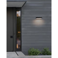 Modern ultra-slim LED wall light mounted on exterior wood siding, emitting warm white light