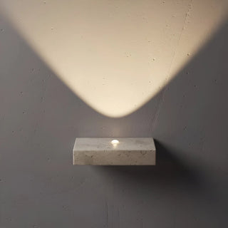 travertine wall lamp creating geometric light patterns on wall