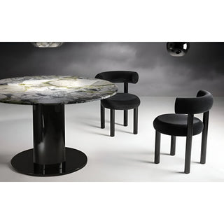 Black minimalist upholstered chairs next to a round designer dining table