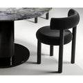 Side view close-up of a minimalist upholstered chair with circular seat