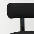 Close-up texture and stitching detail of the minimalist black upholstered chair