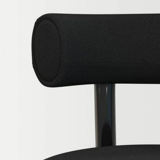 Close-up texture and stitching detail of the minimalist black upholstered chair