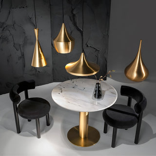 Minimalist chairs around a gold-based marble table in a bold interior