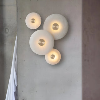 MIRODEMI collection of natural alabaster wall lights in various sizes, creating a sculptural composition on a minimalist wall