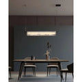 Elegant MIRODEMI marble pendant light with linear brass details, illuminating a refined dining space in a warm, modern atmosphere