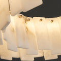 Warm LED light shining through natural marble panels of Mirodemi Cloudstone chandelier