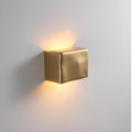 Gold wall-mounted light fixture on a gray background