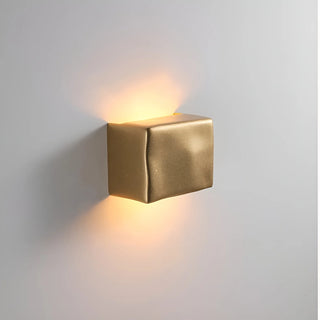 Gold wall-mounted light fixture on a gray background