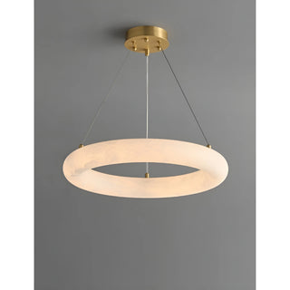 Elegant alabaster ring pendant light suspended from brass frame, minimalist luxury ceiling fixture