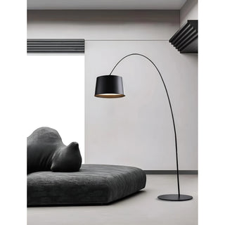 Black arc floor lamp by MIRODEMI in contemporary living room with dark sofa and minimalist décor