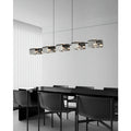 Modern copper linear chandelier with textured glass shades installed above a black dining table in a minimalist interior.