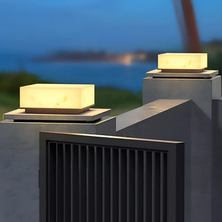 Pair of marble-finish electric pillar lights mounted on modern gate posts with soft warm light
