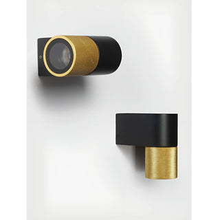 Top and side views of a modern wall sconce with a textured gold cylinder and matte black base, mounted on a white wall
