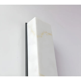 Close-up of the top faux alabaster shade on the LED sconce, revealing realistic marble-like veining