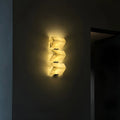 Three-head modern marble wall sconce glowing at night with warm ambient LED lighting