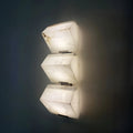 Modern marble wall sconce with three vertical geometric shades and warm LED glow