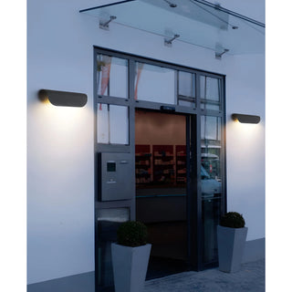 Black Modern Outdoor Wall Lights mounted on a commercial building entrance at night