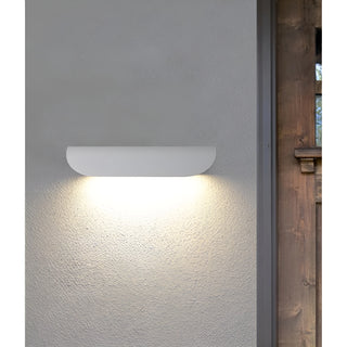Close-up of the white Modern Outdoor Wall Light illuminating a textured wall surface