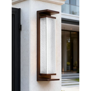 Modern outdoor wall light with textured glass in coffee brown finish, mounted on a light stone wall during the day