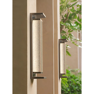 Two modern outdoor wall lights with textured glass in silver finish, mounted on exterior wall to show available size options