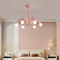 Pink sculptural chandelier in contemporary bedroom with blush accent wall and soft lighting