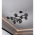 Smoked glass globe chandelier installed on ceiling with modern ring frame design