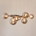 Modern glass globe chandelier illuminated with warm LED bulbs in smoked glass finish