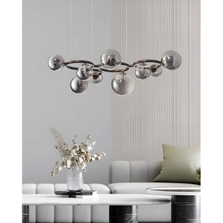 Modern smoked glass globe chandelier suspended above contemporary living room sofa and marble coffee table