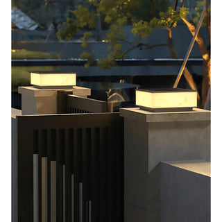 Set of marble-finish outdoor solar lights mounted on modern gate pillars, providing warm architectural illumination