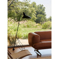 Minimalist tripod floor lamp near window in modern living room interior