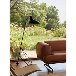 Minimalist tripod floor lamp near window in modern living room interior