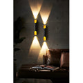 Black and gold wall lights creating warm ambient lighting on dark wall