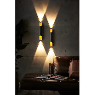 Black and gold wall lights creating warm ambient lighting on dark wall