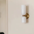 Side view of modern brushed brass wall sconce with glossy white glass shades
