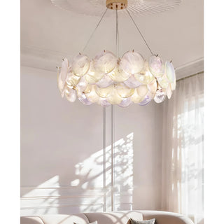 Round white glass chandelier glowing with warm ambient light in elegant interior setting